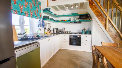 modern kitchen with large fridge, gas stove, oven, microwave, air fryer, nespresso coffee machine, kettle and toaster